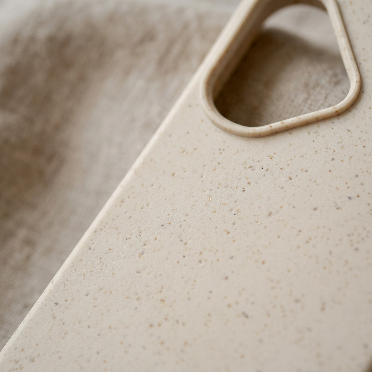 Nahaufnahme der compoCASE Handyhülle in Stone White mit sichtbaren Weizenstroh-Partikeln in der matten Oberfläche
