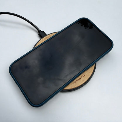 iPhone in schwarzer compoCASE Hülle lädt auf der Holz-Ladestation Single