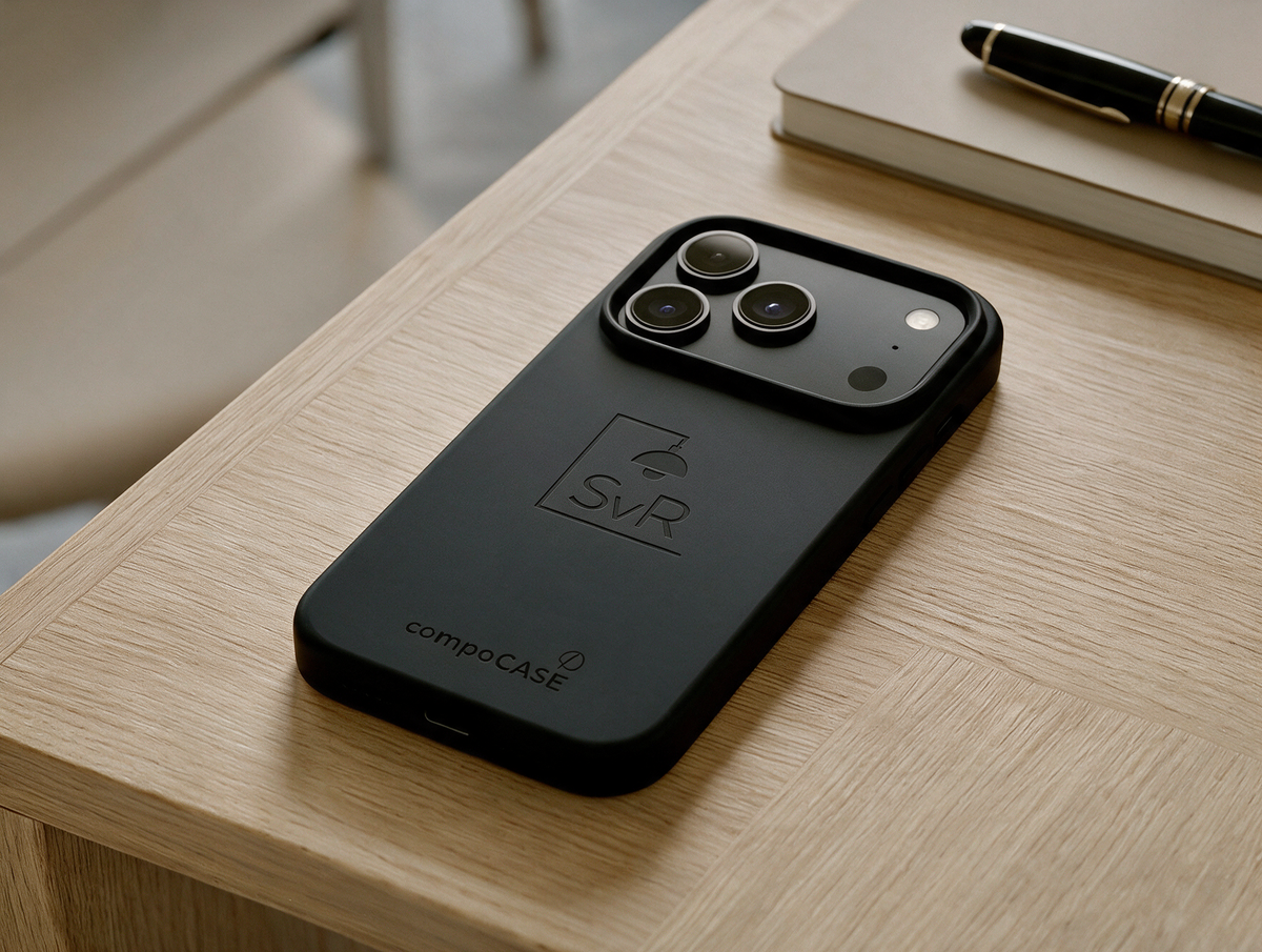compoCASE Handyhülle in Midnight Black mit graviertem Logo auf einem Holztisch