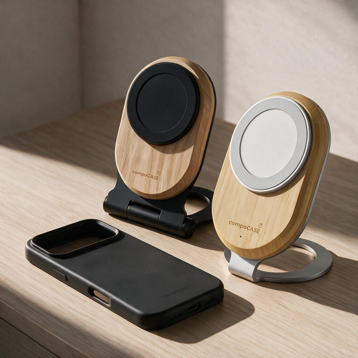 Zwei magnetische Holz-Ladestationen Single Pro neben einem iPhone in schwarzer compoCASE Hülle